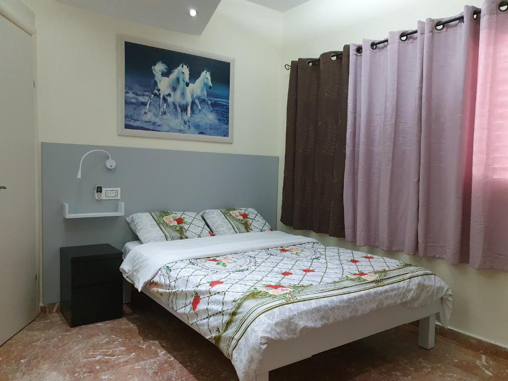 a small bedroom with a bed and a window at Ezore Yam Apartmens - Elmali'akh St. 4 in Bat Yam