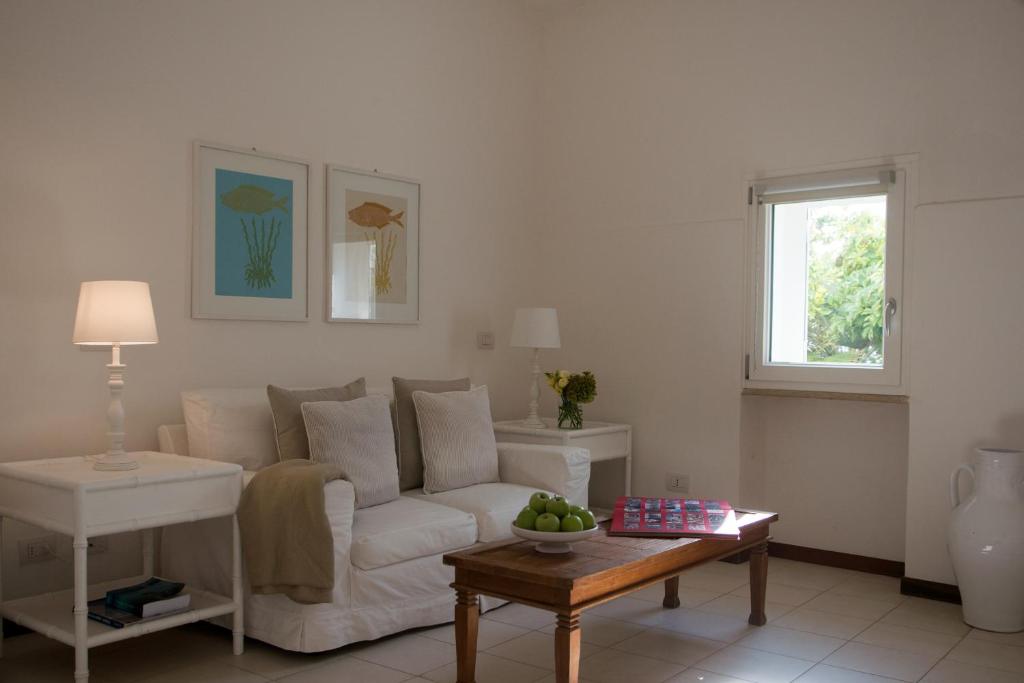 a living room with a white couch and a table at La Peschiera in Monopoli