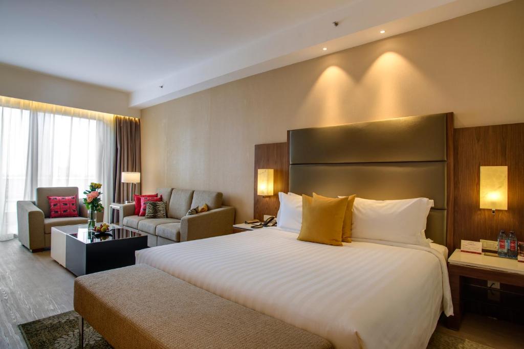 a hotel room with a large bed and a living room at Crowne Plaza Nairobi Airport by IHG in Nairobi