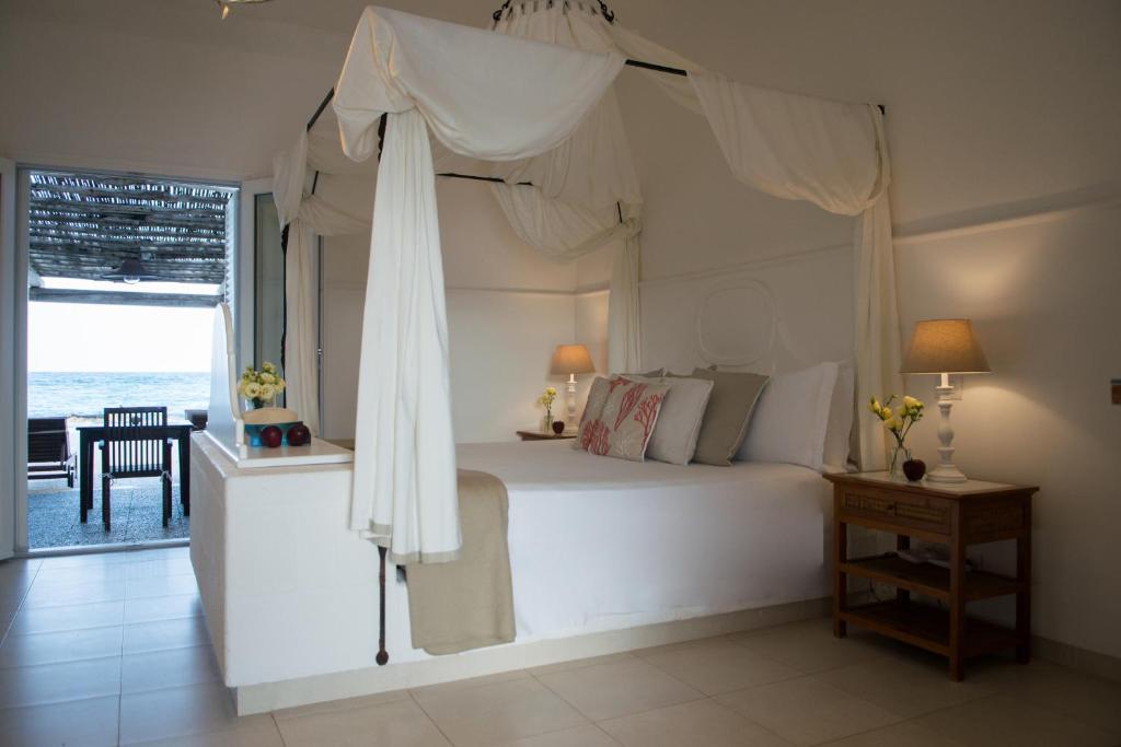 a bedroom with a white bed with a canopy at La Peschiera in Monopoli