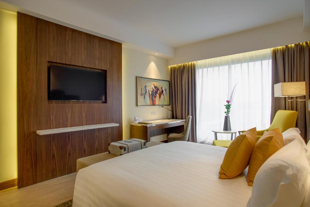 a hotel room with a large bed and a television at Crowne Plaza Nairobi Airport by IHG in Nairobi