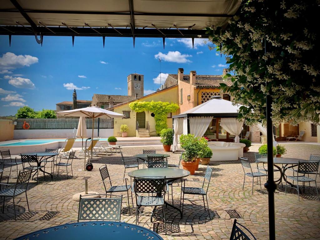 une terrasse avec des tables et des chaises ainsi qu'une piscine dans l'établissement Corte Uccellanda Relais, à Monzambano