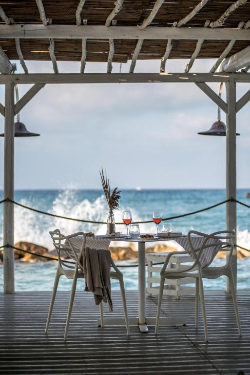 a table and chairs on a deck with the ocean at La Peschiera in Monopoli