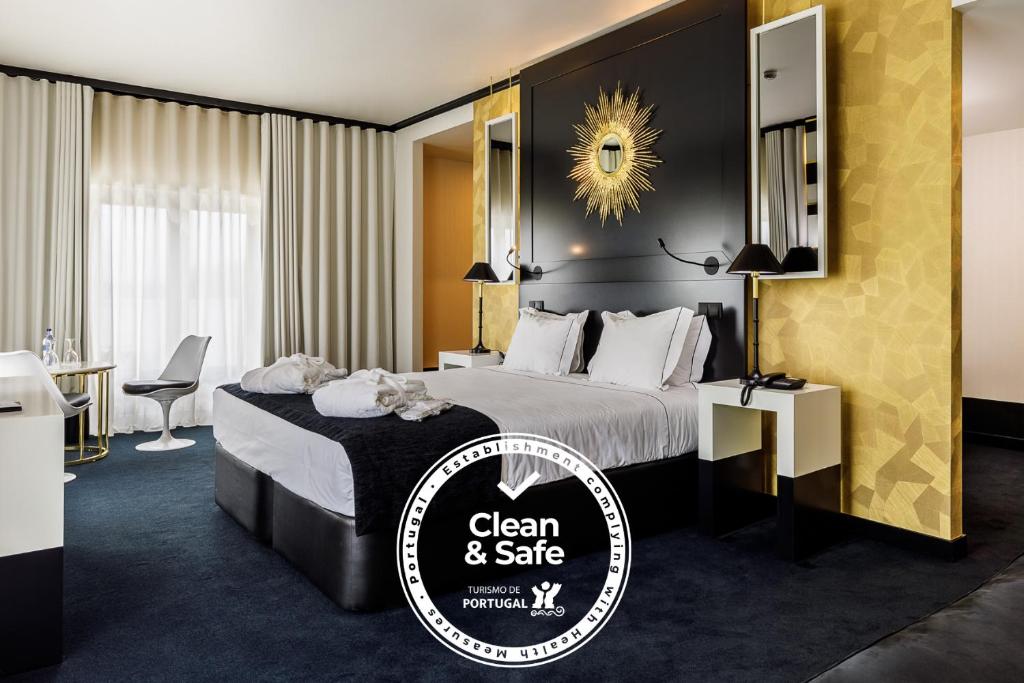 a hotel room with a bed with a sign that says clean and safe at Aurea Fatima Hotel Congress & Spa in Fátima