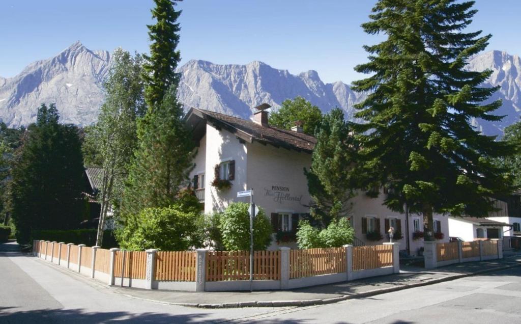 uma casa com uma cerca em frente a uma montanha em Haus Höllental em Garmisch-Partenkirchen