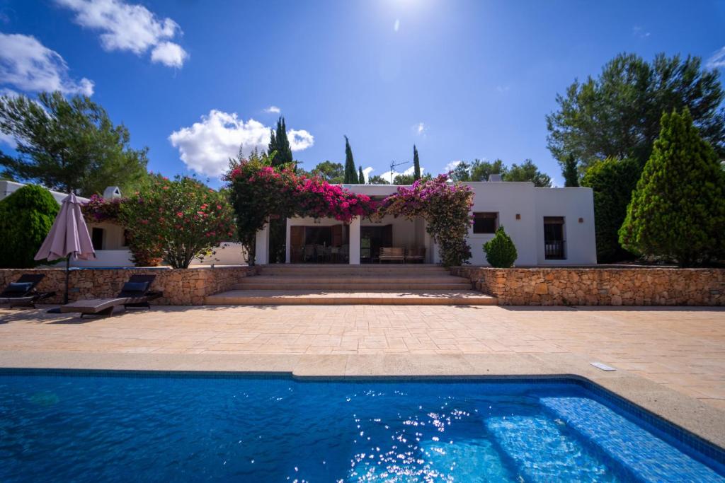 a villa with a swimming pool in front of a house at Villa Tegui is a luxury villa close to San Rafael and 10 min drive to Ibiza Town and San Antonio in Ibiza Town