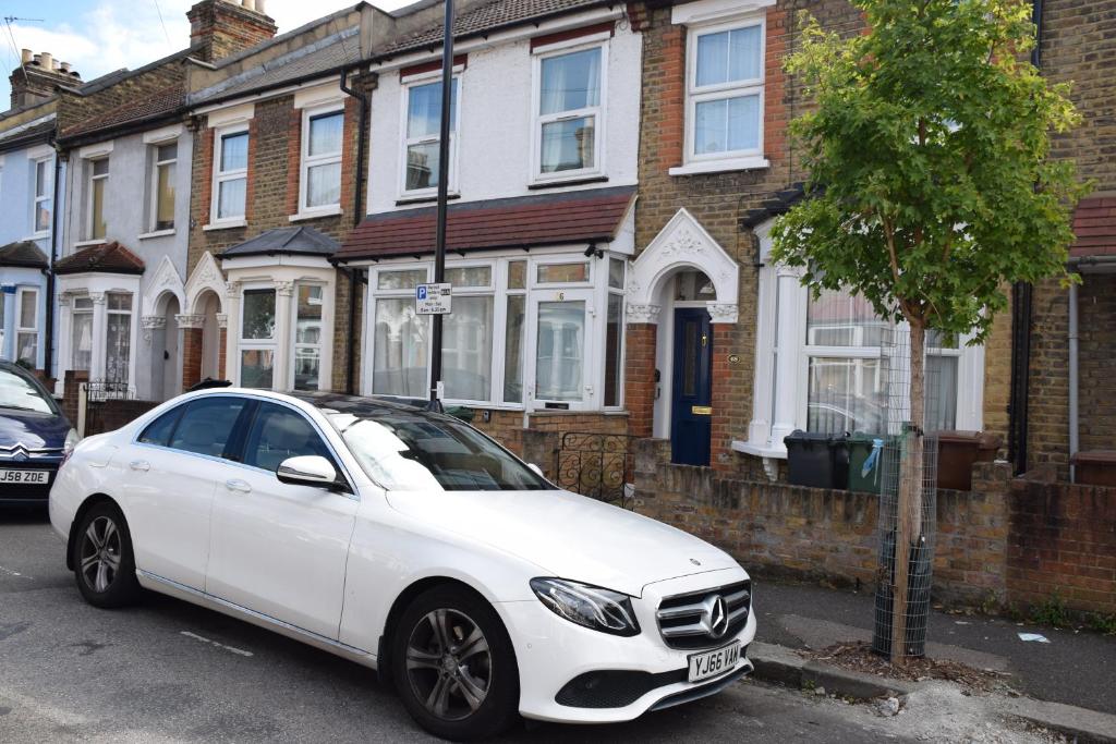a white car parked in front of a house at Three Bedroom House Lancaster Road in London