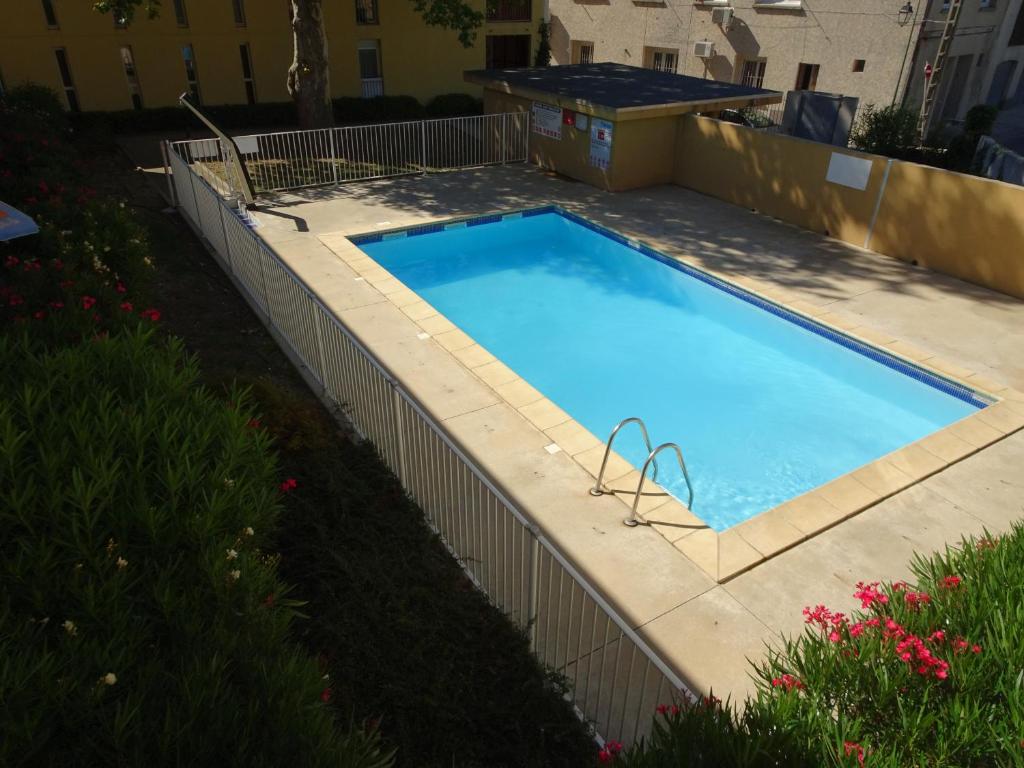 een zwembad met een hek eromheen bij Les Manades in Aigues-Mortes