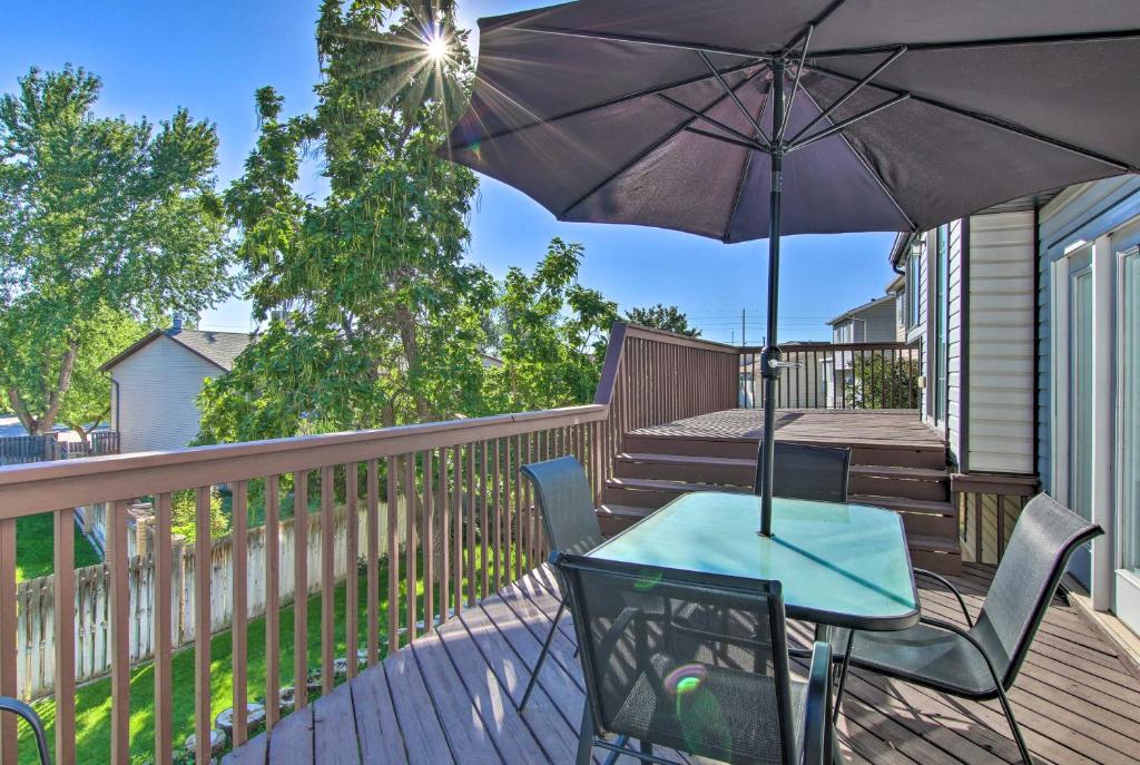 un tavolo e sedie su una terrazza con ombrellone di 4 BR Home Near HAFB, Restaurants, and Snowbasin! a Layton