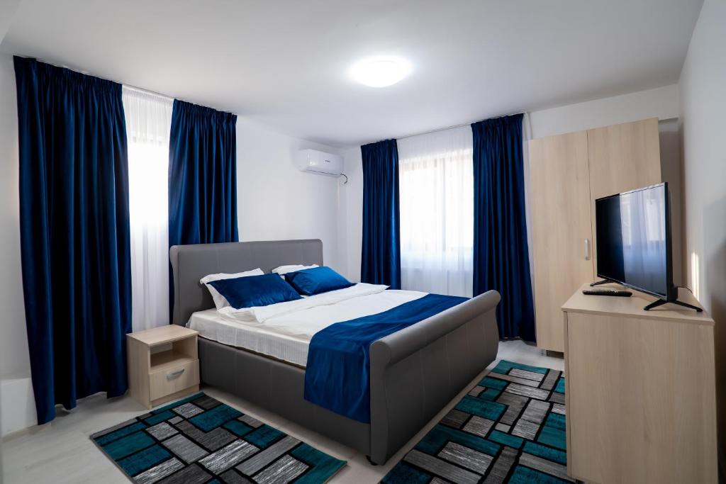 a bedroom with a bed and a flat screen tv at Hotel Simona in Bucharest