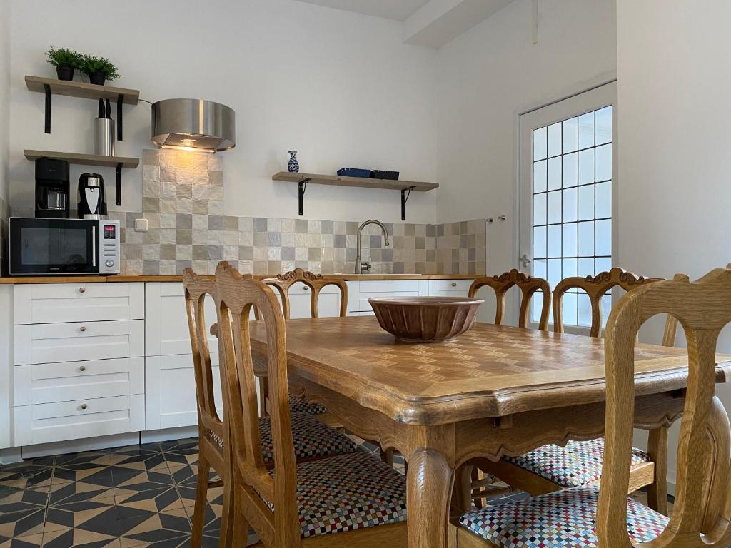uma cozinha com uma mesa de madeira e algumas cadeiras em Authentic Stays - 6p-apartment em Eijsden