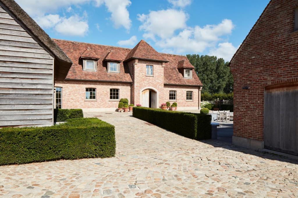 uma grande casa de tijolos com uma entrada de tijolos em B&B Sett em Horebeke