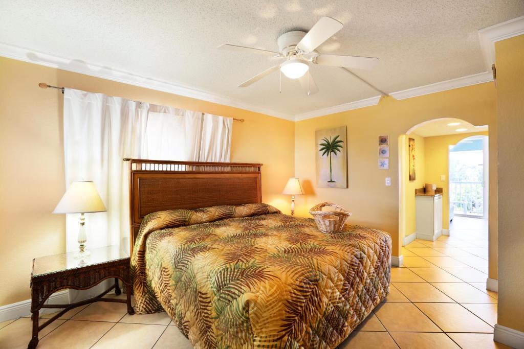 1 dormitorio con 1 cama y ventilador de techo en Barefoot Beach Club en St Pete Beach