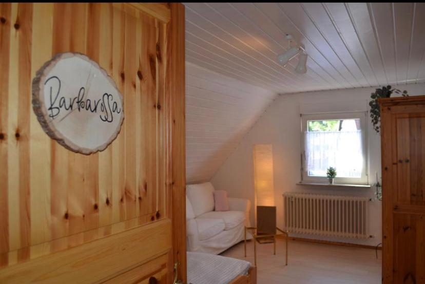 ein Wohnzimmer mit einem weißen Sofa und einem Fenster in der Unterkunft Ferienhaus Bärbelstein Barbarossa in Erlenbach