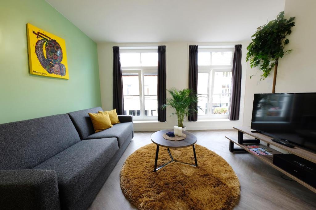 a living room with a couch and a tv at Beautiful 60m2 One-Bedroom Apartment with Terrace in Tiel