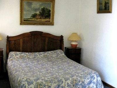 a bedroom with a bed and a picture on the wall at Logis Hôtel Le Vieil Amandier in Trigance
