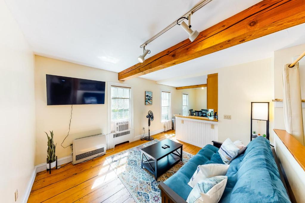a living room with a blue couch and a tv at Stowe Mountain Road Escape in Stowe