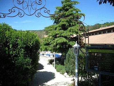 a street light next to a road with a tree at Logis Hôtel Le Vieil Amandier in Trigance