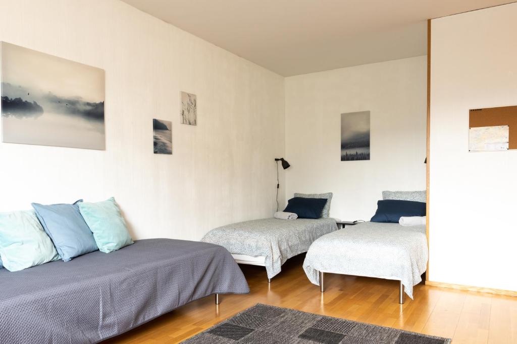 Cette chambre comprend deux lits et une chaise. dans l'établissement Tuure´s studio near to Art Museum, à Turku