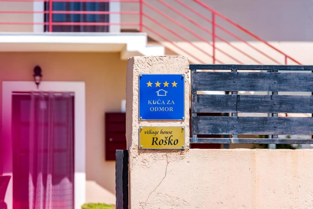 a sign on a wall in front of a house at Holiday Home Rosko in Skradin