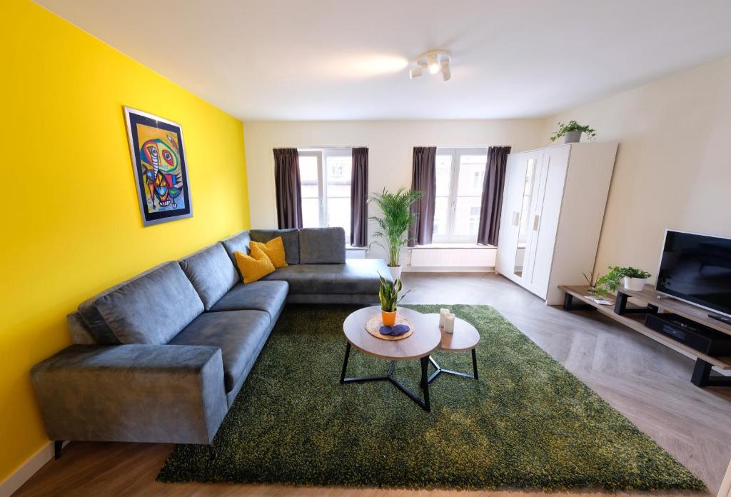 ein Wohnzimmer mit einem Sofa und einem Tisch in der Unterkunft Fantastic 90m2 Two-Bedroom Apartment with Terrace in Tiel