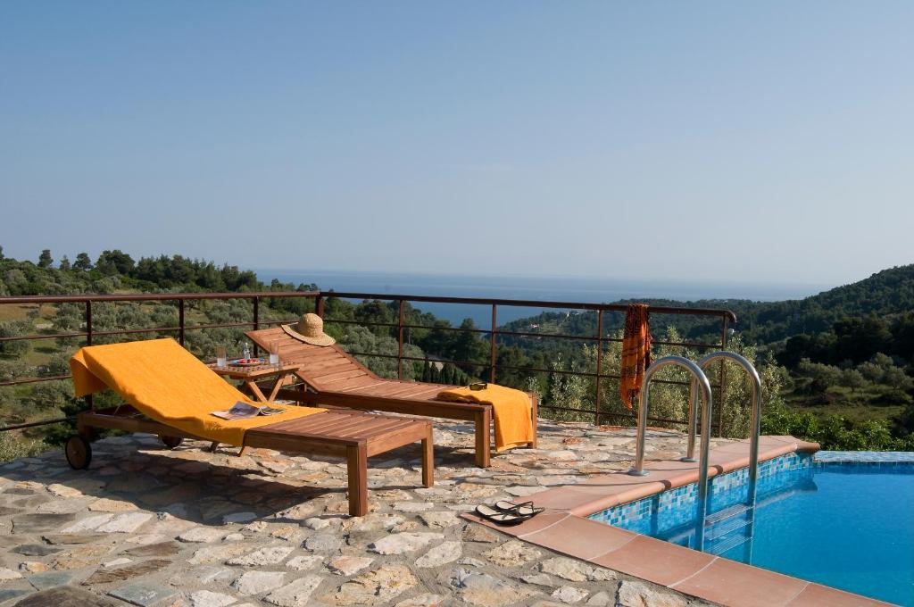 a swimming pool with a table and chairs next to a swimming pool at Alonissos Poikilma Villas exclusive luxury villas in nature with private pools in Alonnisos