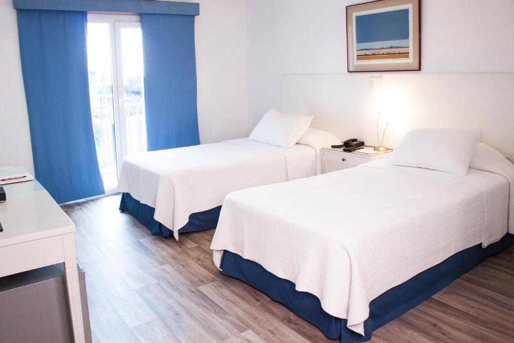 Cette chambre comprend 2 lits et une fenêtre. dans l'établissement Hotel Cecilia, à Asuncion