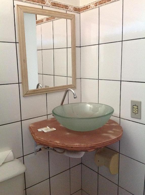 La salle de bains est pourvue d'un lavabo à bol vert sur une table. dans l'établissement Pousada Por do Sol, à Sao Jorge