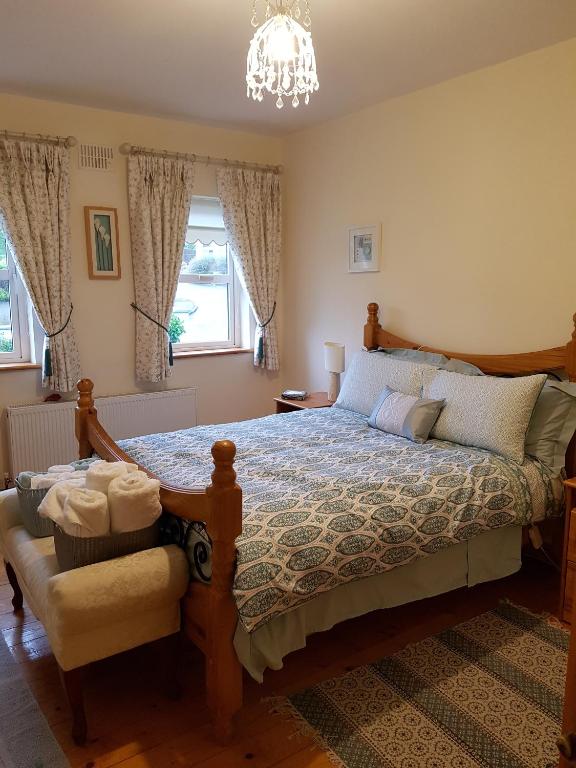 1 dormitorio con cama y lámpara de araña en Hillgrove House en Boyle
