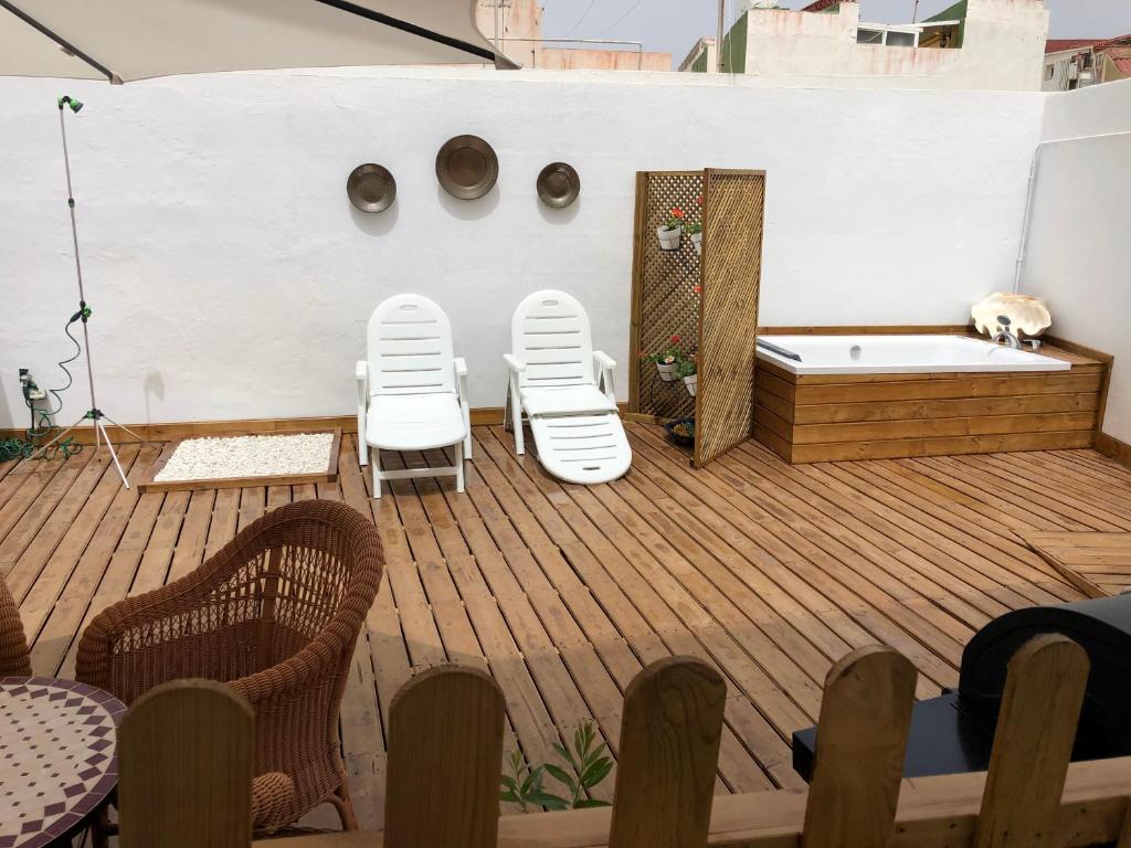 a deck with three chairs and a bath tub at Punta Brava Relax in Puerto de la Cruz