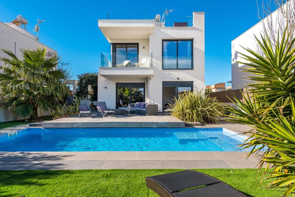 una villa con piscina frente a una casa en Villa 11 Oasis del Mare, 5min Strand, Wifi, Klima, Fußbodenheizung, en Sa Ràpita
