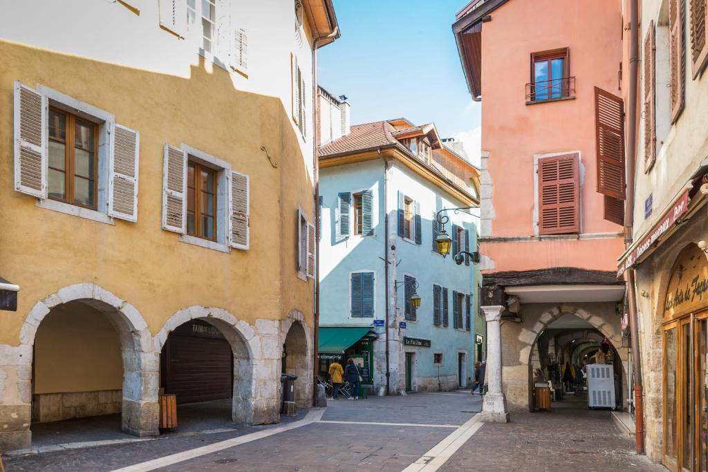 an alley in an old town with colorful buildings at Le Veyrier - Small studio for 2 people in the heart of the old town in Annecy