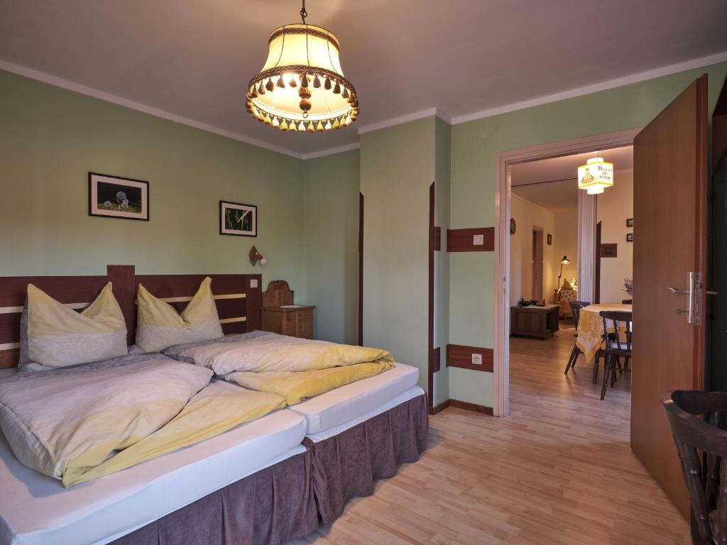 a bedroom with a large bed and a chandelier at Hardy Apartman in Keszthely