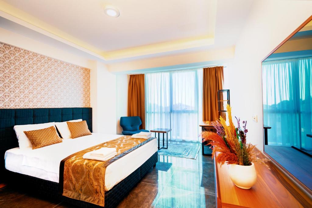 a hotel room with a bed and a desk and window at Continent Luxury Suites Sakarya in Sakarya