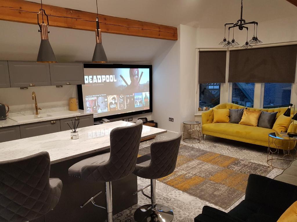 uma cozinha e sala de estar com um sofá amarelo em Central Windermere Luxury two bed Apartment Dog Friendly em Windermere