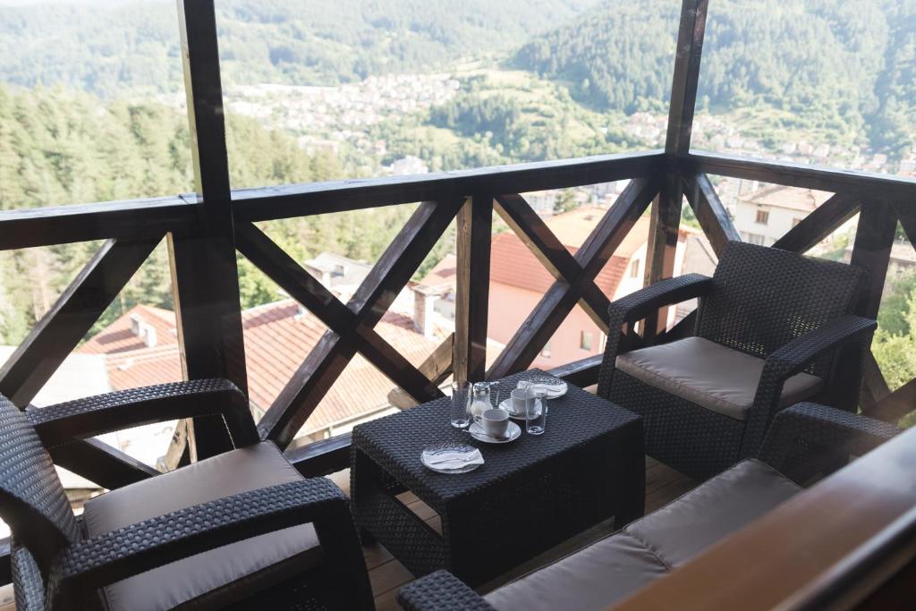 a balcony with chairs and a table with glasses on it at Planinski Polah House in Devin