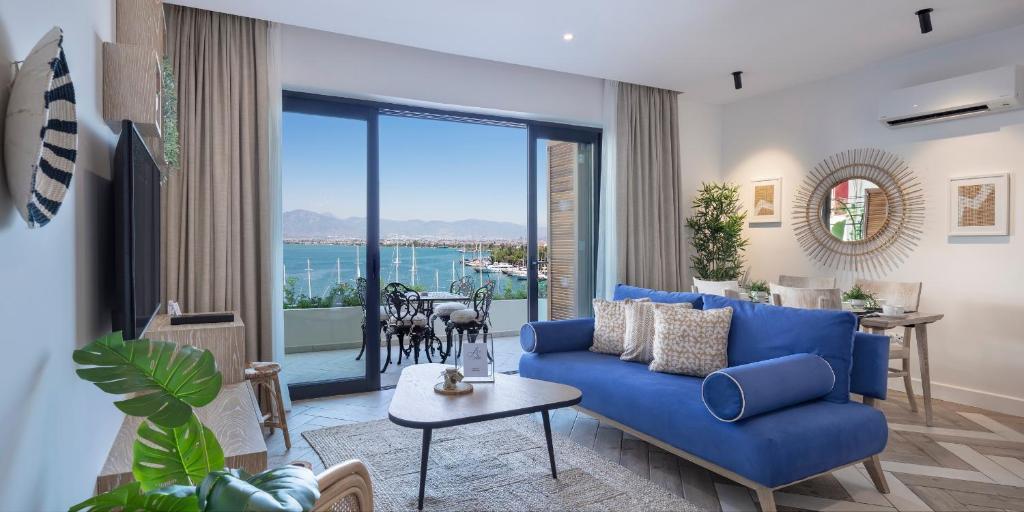 a living room with a blue couch and a large window at Ada Dreams City in Fethiye