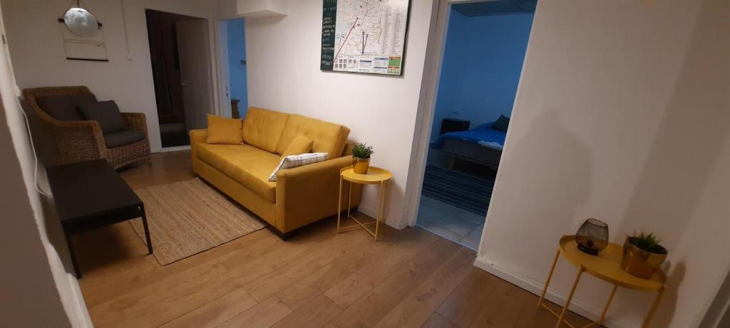 a living room with a yellow couch and a table at Dotan's Boutique Guesthouse - By The Beach! in Tel Aviv