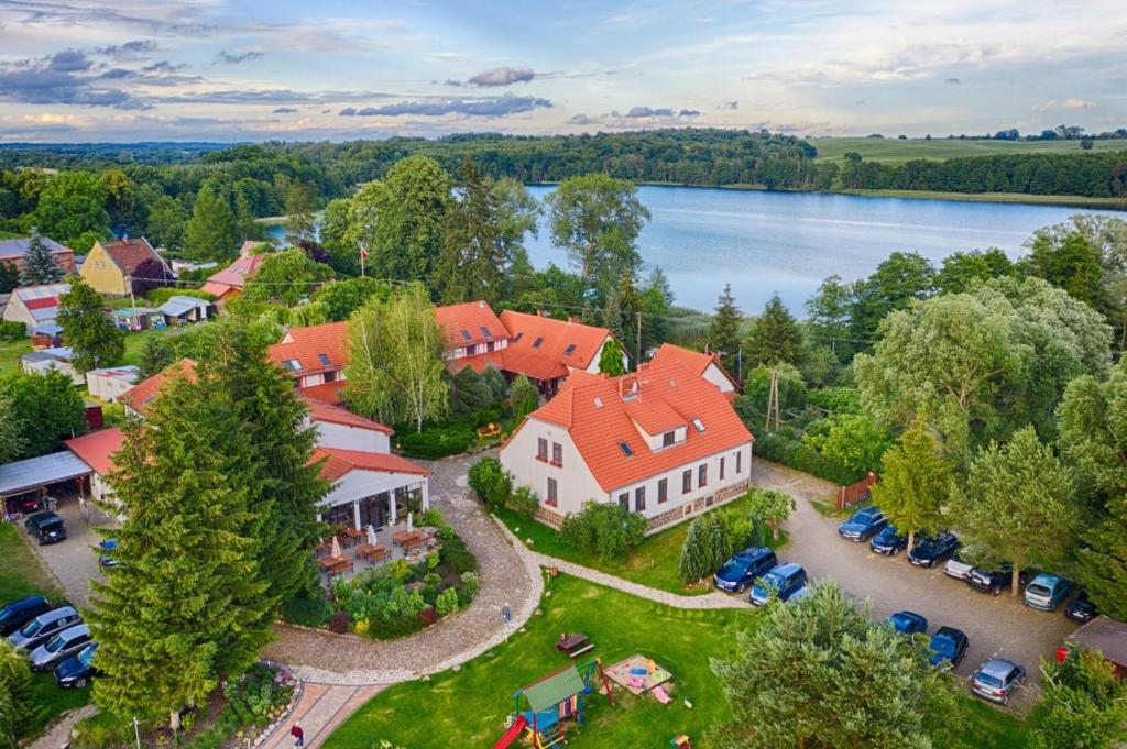 an aerial view of a large house with cars parked in a yard at Folwark Na Półwyspie in Nowe Worowo