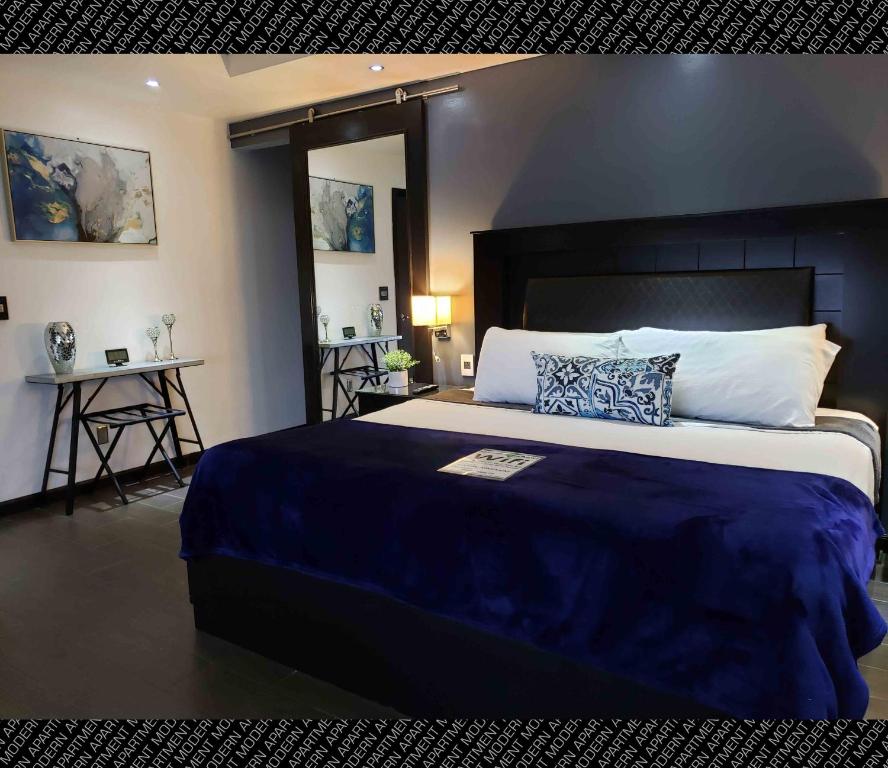 um quarto com uma cama grande e um cobertor azul em The Condo (by Modern Apartments) em Rosarito
