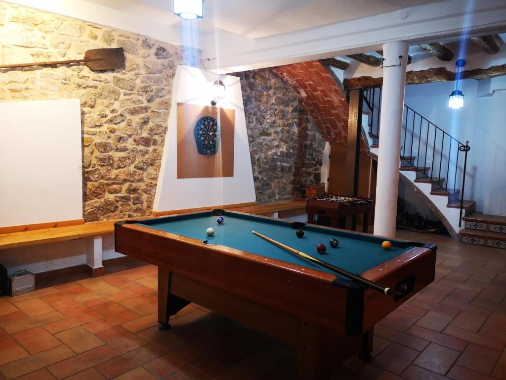 a pool table in a room with a staircase at L'Antic Forn de Paüls in Paúls