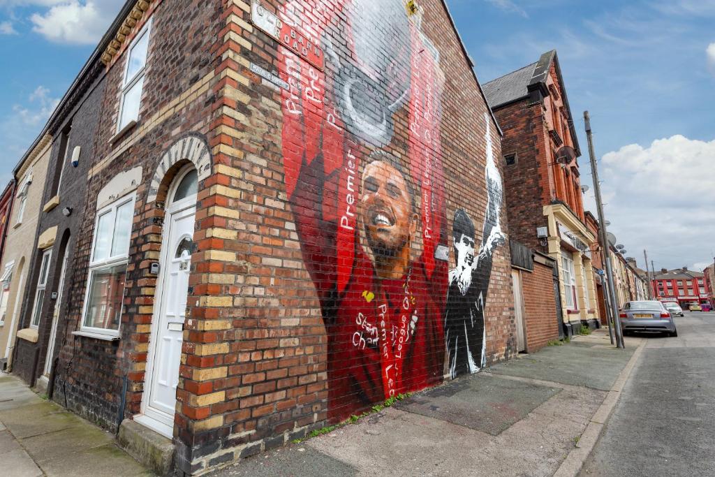 Un murale di un uomo sul lato di un edificio di mattoni di The World Famous Henderson House FREE PARKING a Liverpool