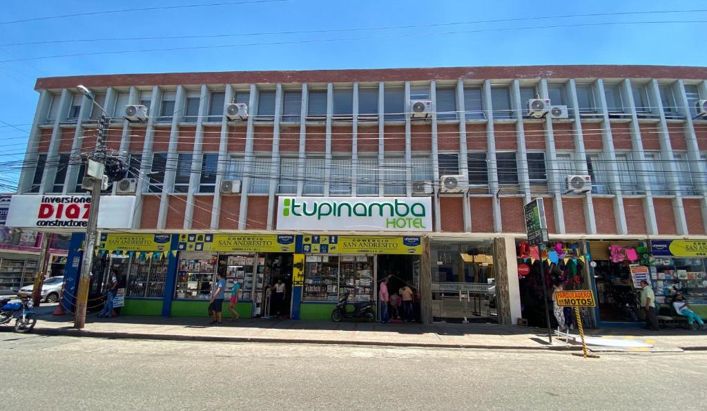 a store on the side of a building on a street at Hotel Tupinamba Neiva in Neiva