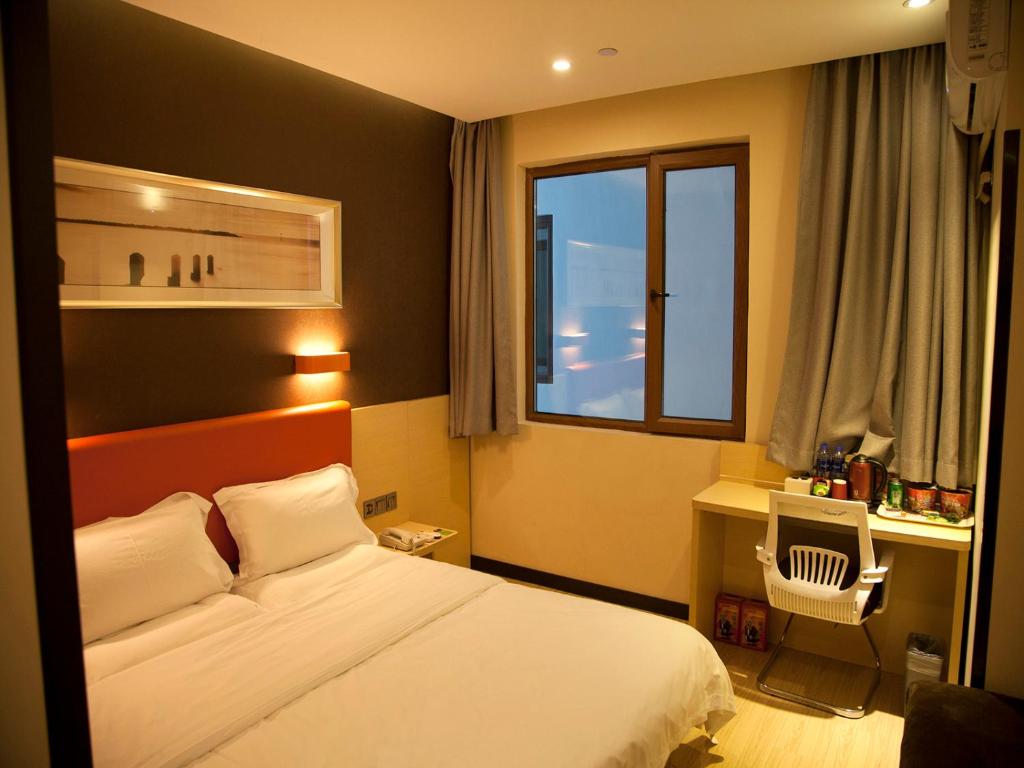 um quarto de hotel com uma cama e uma janela em 7Days Premium Harbin Xuefu Road Branch em Harbin