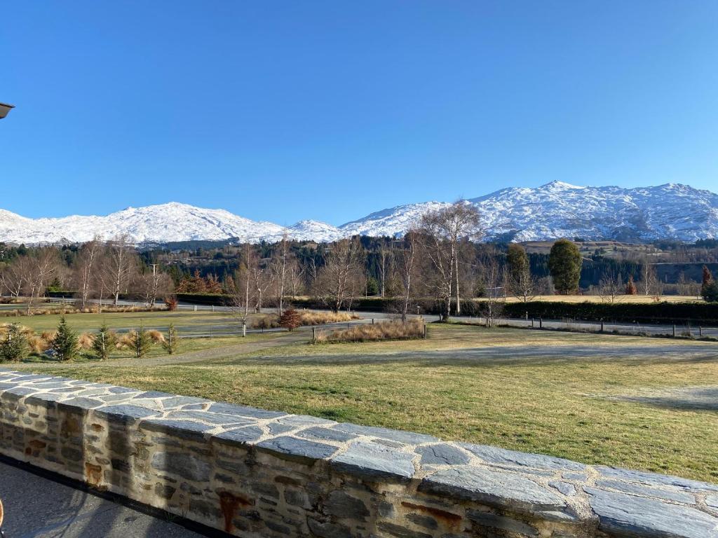 a park with snow covered mountains in the background at Maunga View in Queenstown