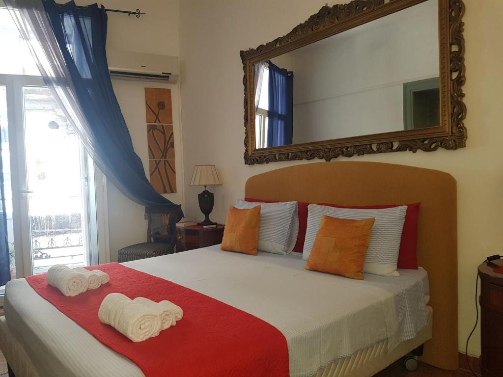 1 dormitorio con 1 cama grande y espejo en la pared en House Ròdue The Historic Center Palermo, en Palermo