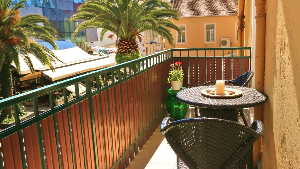 un tavolo e sedie su un balcone con palme di Double bedroom apartment on great location with balcony!! a Spalato (Split)