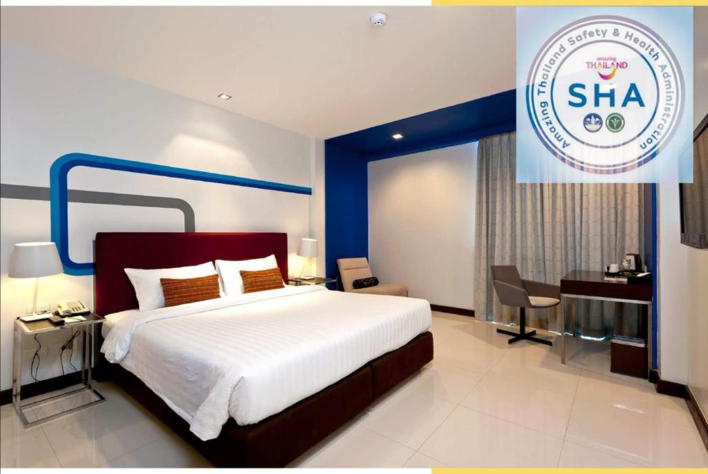 a hotel room with a bed and a sign that says sha at FX Hotel Metrolink Makkasan in Bangkok