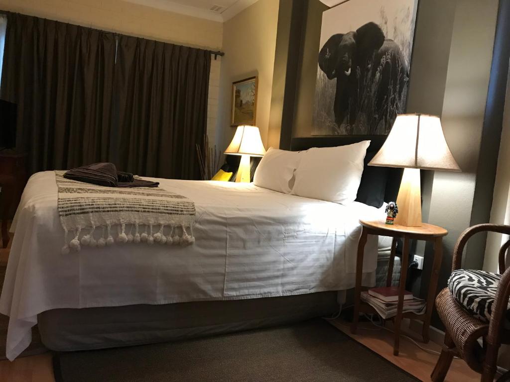 a bedroom with a large white bed with two lamps at Yellow Gum Bed and Breakfast in Katanning