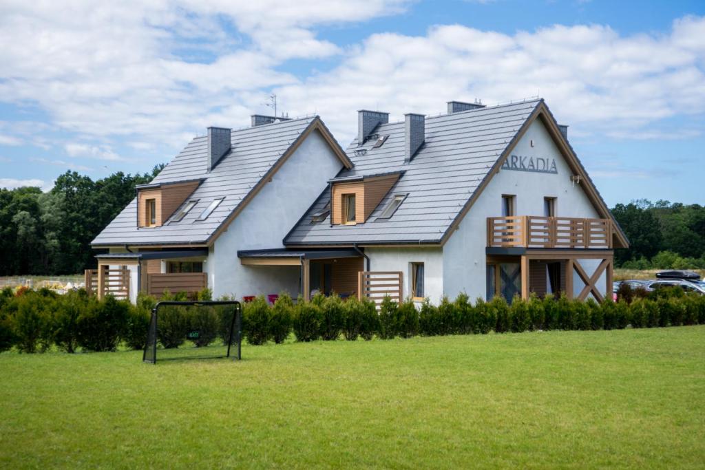 une maison avec des panneaux solaires en haut dans l'établissement Villa Arkadia RESORT, à Łukęcin